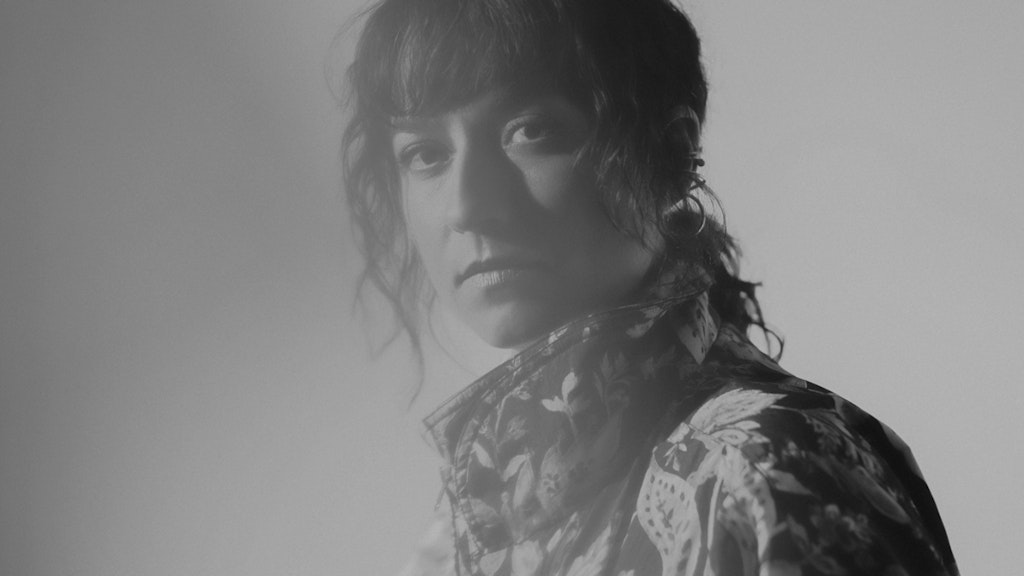 Portrait de Lucia Cadotsch. Elle regarde la caméra à travers un voile de lumière.