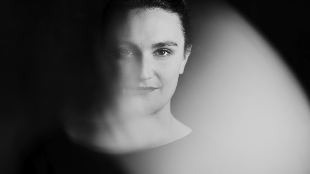 Photo en noir et blanc de Simone Felber. Elle regarde directement la caméra avec un léger sourire sur le visage.