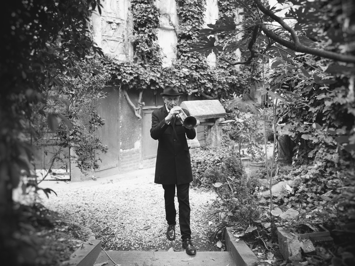 Erik Truffaz joue sa trompette dans un jardin