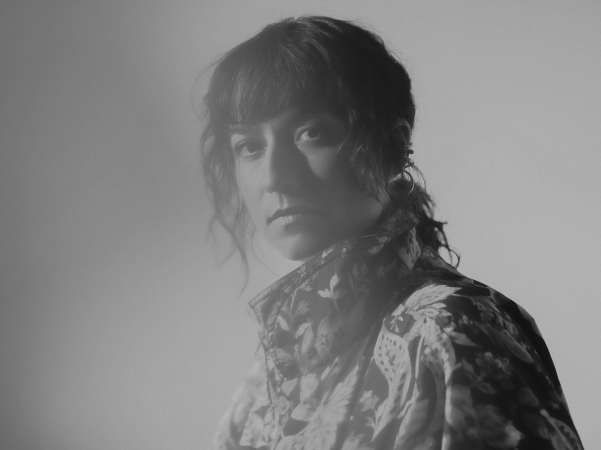 Portrait de Lucia Cadotsch. Elle regarde la caméra à travers un voile de lumière.